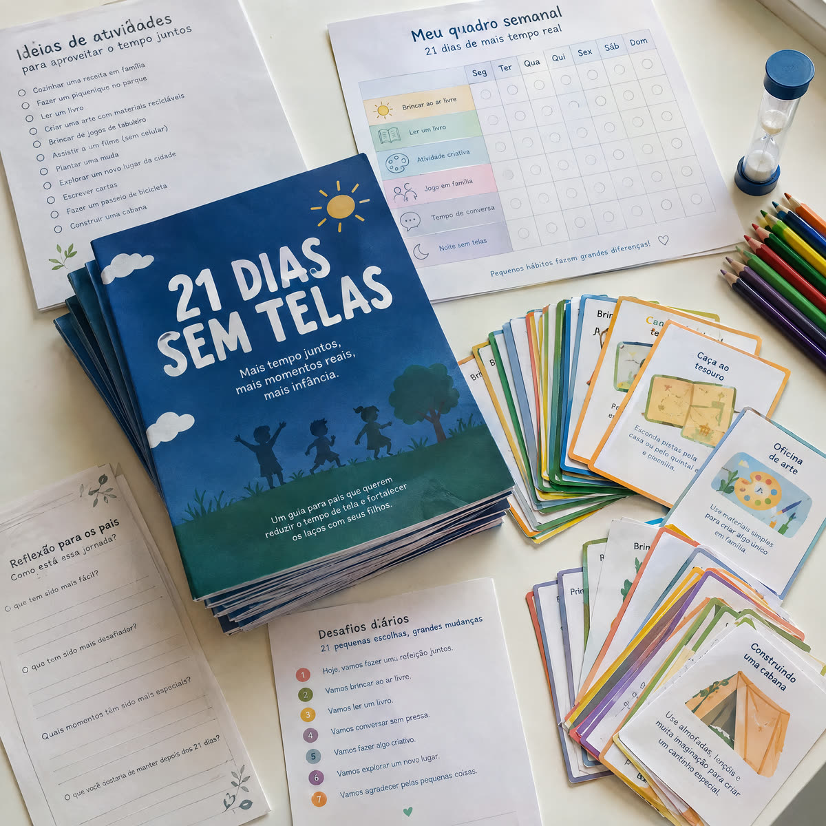Todos os materiais impressos do Desafio espalhados na mesa: o guia 21 Dias Sem Telas, o quadro semanal, as folhas de desafios diários e o baralho de cartas de jogos